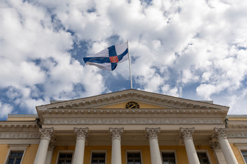 Finnish state flag flying over government building in Helsinki