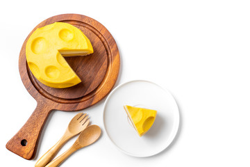 Flat lay shot of cheesecake on wooden plate with black coffee on white background, copy space