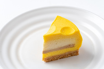 Slice Of Tom & Jerry Cheesecake On White Plate. Closeup View