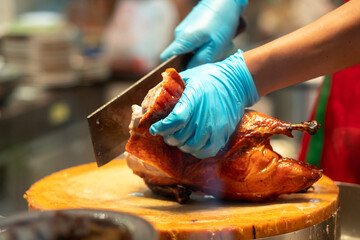 Chinese chef Preparation of Peking Roast Duck with protective gloves 