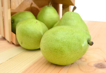 pears isolated in wooden crate on wooden board