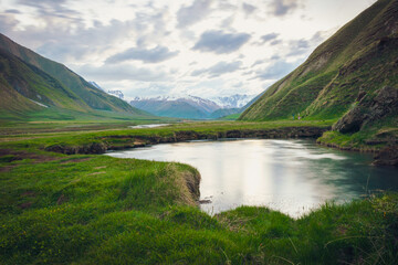 mineral lake in Truso valley with green landscape and mountains in the background
