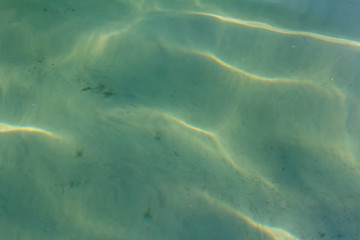 Transparent water in the reservoir. Sandy bottom of the lake.