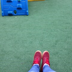 p&eacute;s com t&ecirc;nis vermelho na grama