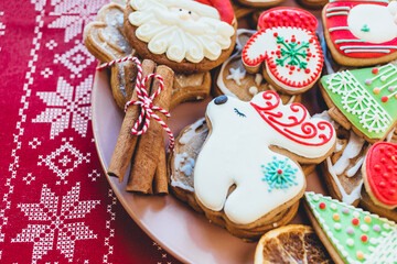 Homemade christmas gingerbread cookies on plate on wooden background. Snowflake, star, tree, snowman, deer shapes. Holiday, celebration and cooking concept. New Year and Christmas postcard, close up.