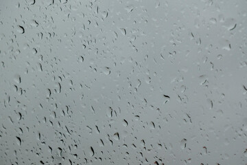 texture of bokeh drops on glass in front of urban park landscape