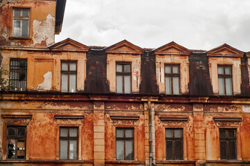 Fototapeta na wymiar Old vintage dacayed neglected building facade closeup in cloudy day