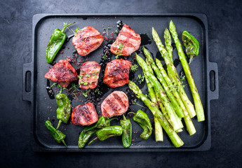 Traditional barbecue Iberian pork filet medaillons with green asparagus and chili offered as top...