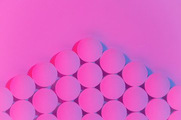 Geometrc pattern of round medical pills on pink background