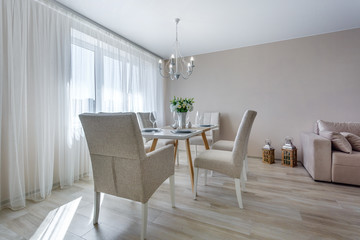 served table with a bouquet of roses in interior of modern luxure guest room in studio apartments in minimalistic style
