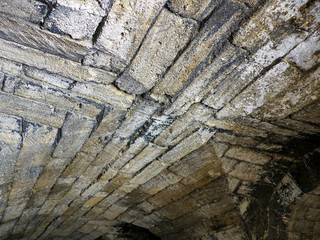 Abstract background of the old wall of black natural stone with cracks and scratches. Landscape...