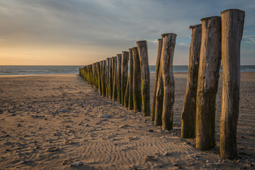 Wooden fence on the beach of Calais at sunset.