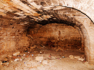 Mystic interior of an ancient dungeon. An old abandoned tunnel in an underground wine cellar. Entrance to catacombs. Dungeon An old stone fortress. As creative background for staging dark design.