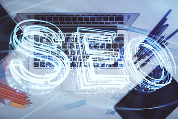 Double exposure of SEO drawing over study table background with computer. Concept of search. Top view.