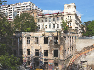 Fototapeta premium Odessa, Ukraina - 17 maja 2017: Panoramiczny widok na ulicę z rozkładającymi się domami w biednej okolicy. Zrujnowany budynek po klęsce żywiołowej. Zapewnij schronienie osobom bezdomnym i narkomanom.