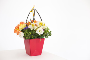 Summer bouquet of colorful flowers in a red box, on the white background