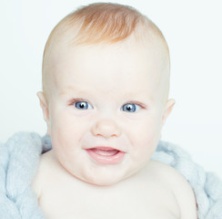 little cute red head baby in scarf all over him close up isolated, adorable kid winter clothers smiling, lifestyle real people concept