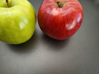 macro view of a red and a green apple on a black background