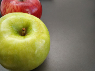 macro view of a red and a green apple on a black background