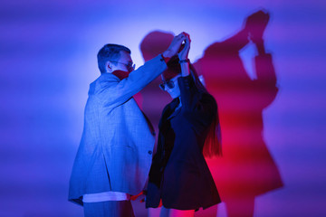 Couple of lovers dancing in red blue neon lights