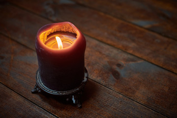 Big candle on wooden table