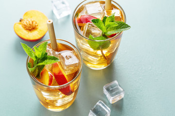 Iced tea with peach and ice cubes