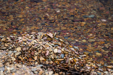 Beautiful colorful rocks on the shores of Bowman Lake in Glacier National Park Montana