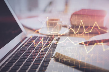 Double exposure of financial chart drawing and desktop with coffee and items on table background. Concept of forex market trading