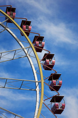 Ferris wheel. Open booths of the Ferris wheel at the sky with beautiful clouds. Rides at city Park.