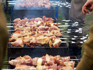 Grilled kebab cooking on metal skewer. Roasted meat cooked at barbecue.Traditional eastern dish, shish kebab. Grill on charcoal and flame, picnic, street food