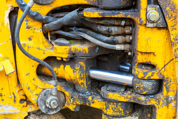 Yellow hydraulic system of a construction crane with drips and spots of oil