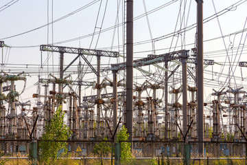 Power lines. High voltage power pylons against blue sky and sun rays