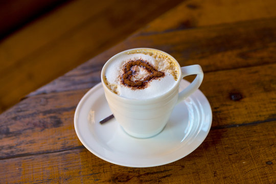 Cup of fresh coffee. Fresh coffee for morning breakfast on wooden background. The pattern of the heart.