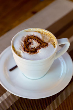 Cup of fresh coffee. Fresh coffee for morning breakfast on wooden background. The pattern of the heart.