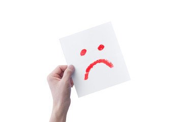 Hand holding white paper with hand drawn unhappy face emoticons isolated on white background. with clipping path.