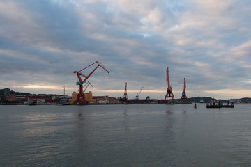 Fototapeta na wymiar Gothenburg, Sweden - June 17 2019: the view of cranes in Gothenburg harbour at sunset light on June 17 2019 in Gothenburg, Sweden.