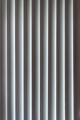 Vertical window blinds. Real blind curtains. Striped background with silver jalousie