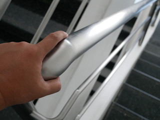 man hand on the handrail or railing in office.