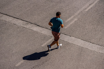 A man doing a jogging sport wearing a mask on the street