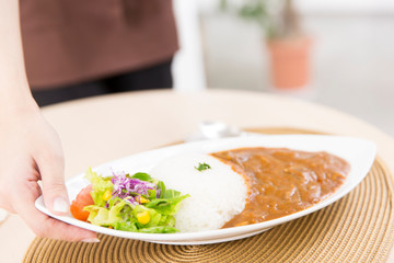 料理を運ぶカフェ店員