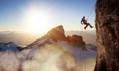 Epic Adventurous Extreme Sport Composite of Rock Climbing Man Rappelling from a Cliff. Mountain...