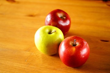 Three apples on a wooden table