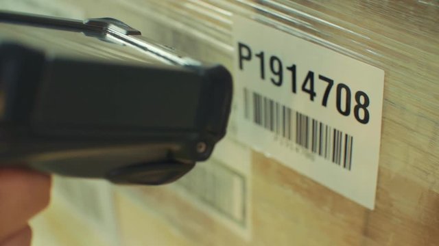 Close-up shot of scanning the barcode on the package with a barcode reading machine.