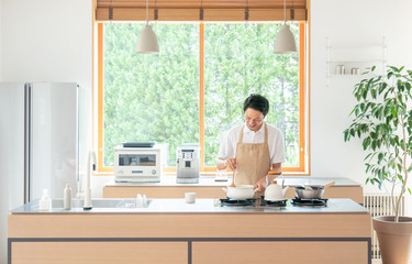 キッチンで料理する若い男性