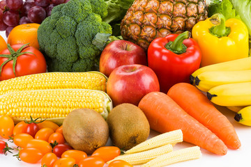 Close-up variety of fresh fruits and vegetables on bright background