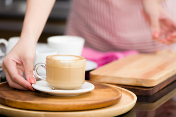 Fototapeta na wymiar Hand of a barista is served coffee to customers.