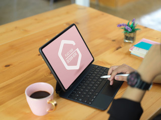 Female using mock up digital tablet with keyboard and stylus on table