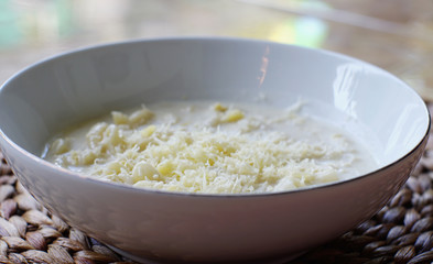 Macaroni soup with milk sauce and topped with grated cheese