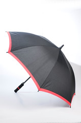 Whole open, closed, vertical black with red lining umbrella isolated on white background