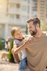 Dad holding his cute daughter and smiling